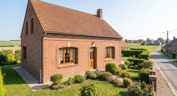 Une photographie professionnelle d'une maison individuelle typique de la région Hauts-de-France, prise de façade en lumière naturelle, montrant l'extérieur du bâtiment avec clarté. Le style architectural doit être représentatif des habitations locales de Somme. L'image doit être nette, sans texte ni filigrane, et illustrer le contexte résidentiel sur lequel intervient le diagnostiqueur dans sa zone de service.